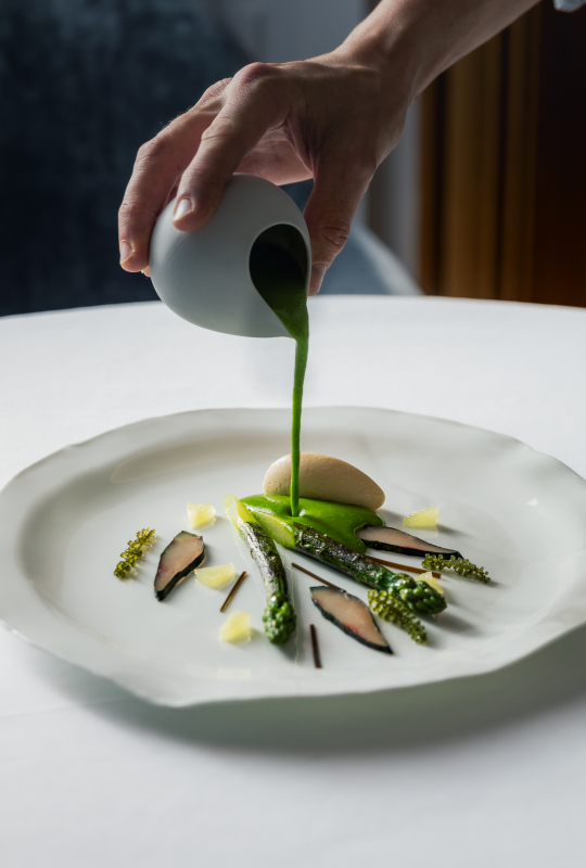Un plat raffiné avec des asperges, des champignons et une sauce verte délicate.