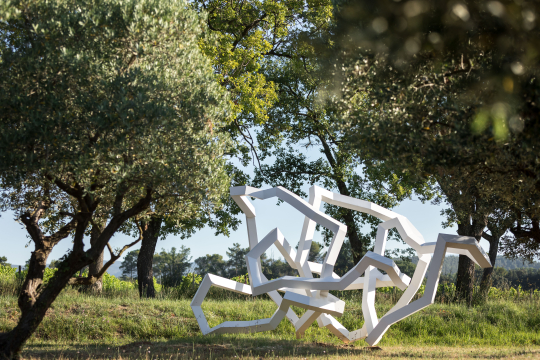 Sculpture abstraite dans un paysage verdoyant et paisible.