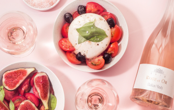 Un délicieux plateau de burrata, de tomates, de figues et de vin rosé, parfait pour un repas gourmand.