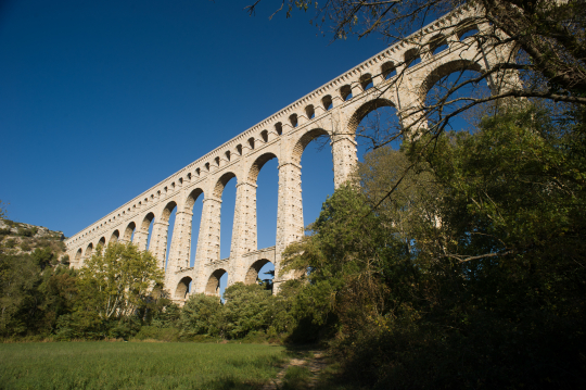 L'aqueduc romain de Pont du Gard, un chef-d'œuvre architectural impressionnant sous un ciel bleu.