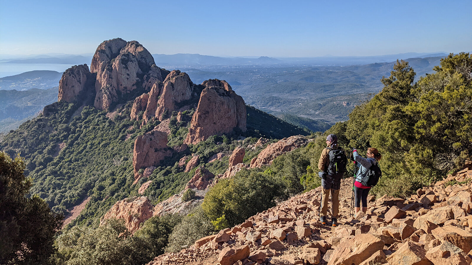 Deux randonneurs admirent un paysage montagneux spectaculaire et une vue panoramique.