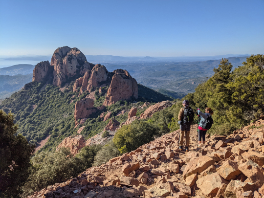 Deux randonneurs admirent un paysage montagneux spectaculaire et une vue panoramique.