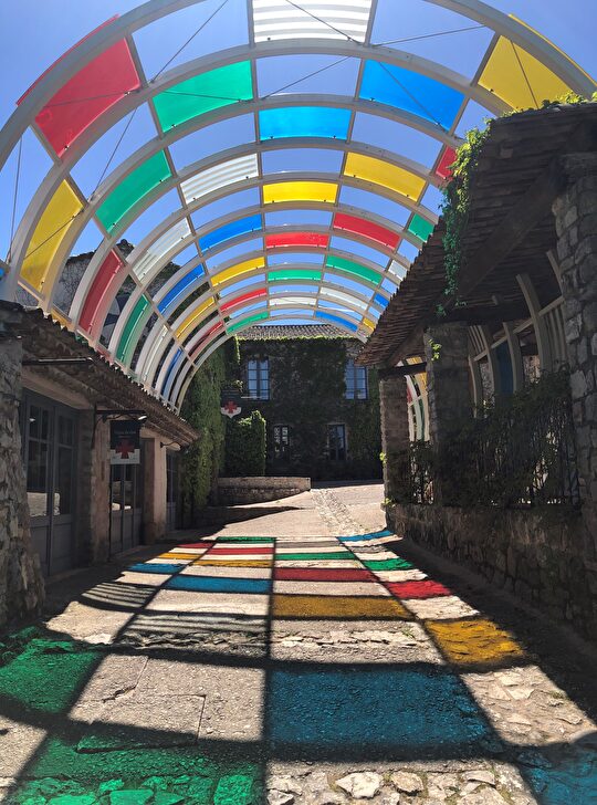 Un beau passage couvert coloré avec un toit en verre, illuminant le chemin.