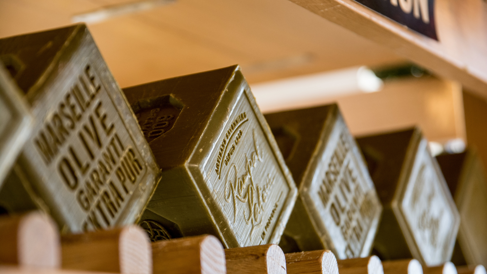 Des boîtes d'olives de Marseille extra vierge sont exposées dans une boutique.