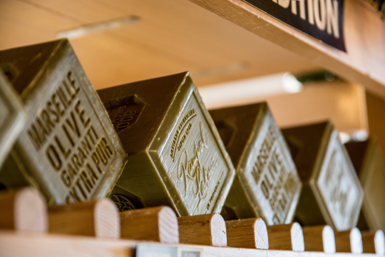 Des boîtes d'olives de Marseille extra vierge sont exposées dans une boutique.