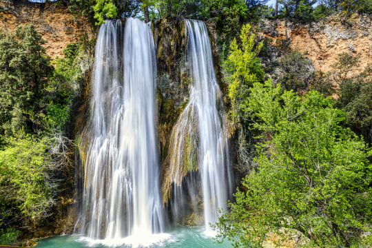 Cascade impressionnante dans un paysage verdoyant et naturel.