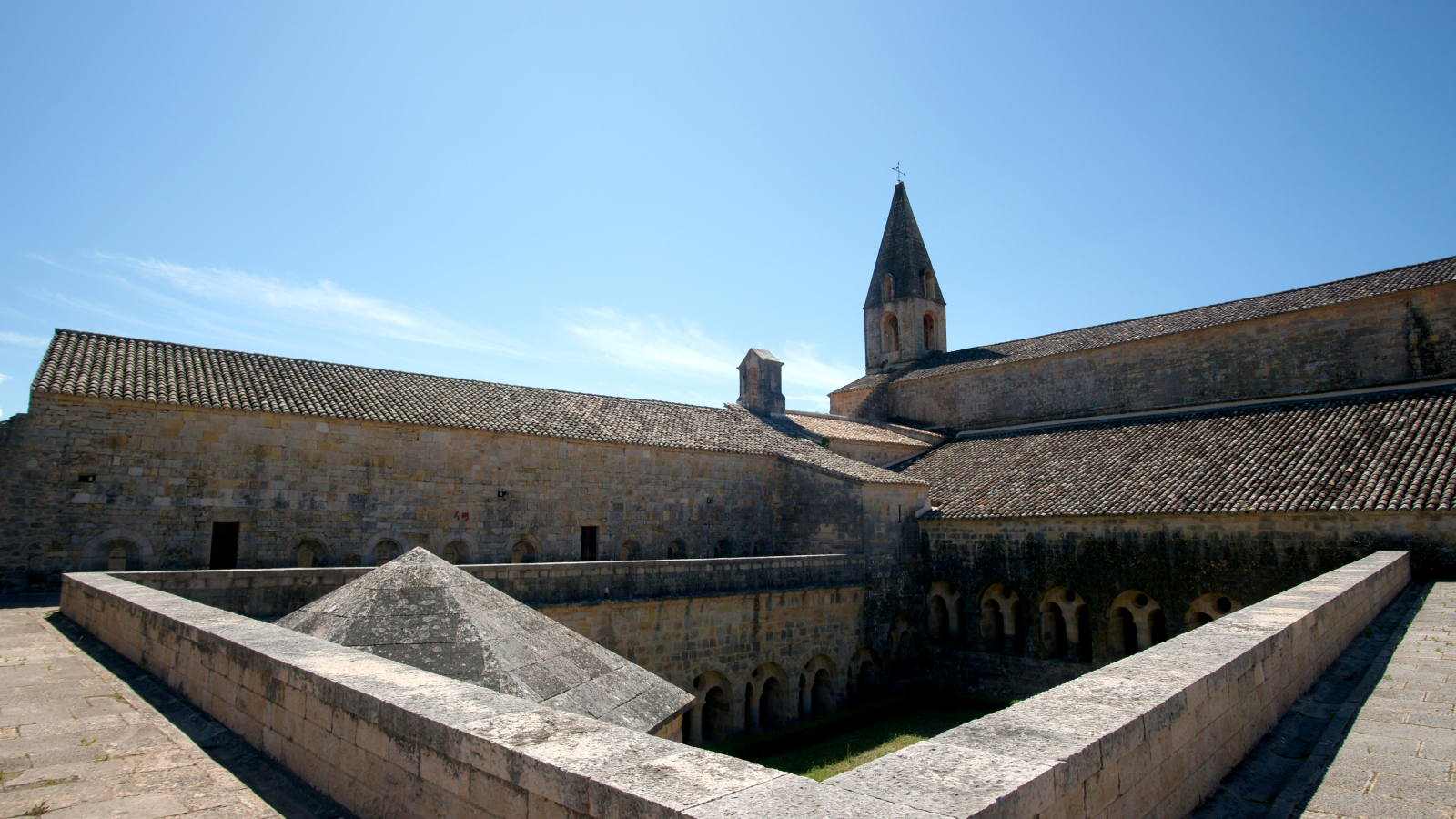 Vue extérieure de l'abbaye de Cluny, avec ses murs en pierre et son toit en tuiles.
