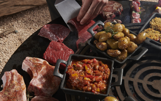 Un serveur prépare un buffet de viandes et d'accompagnements succulents pour les convives.