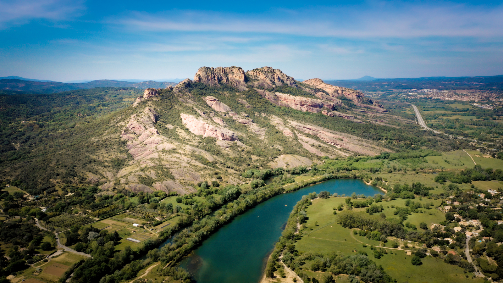 Paysage pittoresque d'une rivière et de falaises rocheuses dans un environnement verdoyant.