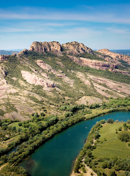 Paysage pittoresque d'une rivière et de falaises rocheuses dans un environnement verdoyant.