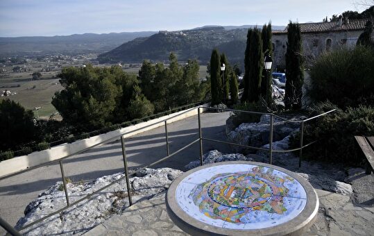 Vue panoramique sur la vallée et carte de la ville depuis un escalier.