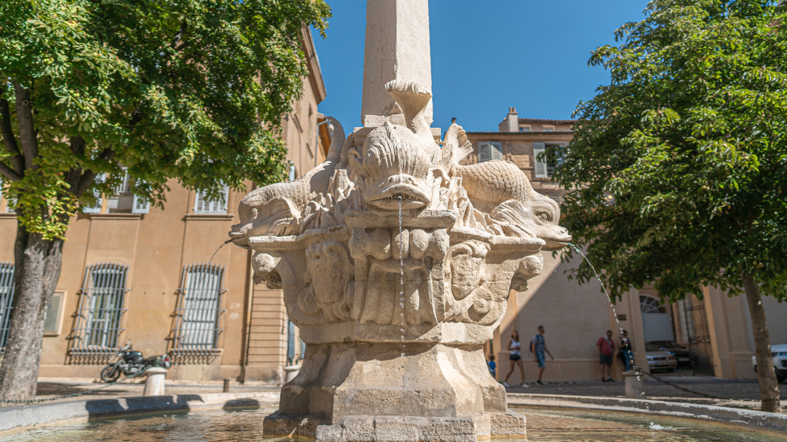 Fontaine des poissons à Nîmes, sculpture monumentale en pierre avec des poissons.