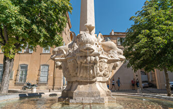 Fontaine des poissons à Nîmes, sculpture monumentale en pierre avec des poissons.