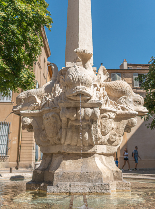 Fontaine des poissons à Nîmes, sculpture monumentale en pierre avec des poissons.