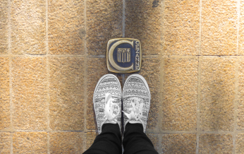 Panier de chaussures devant le logo Cezanne sur un mur de briques.