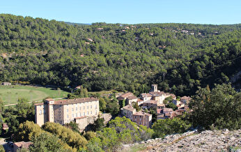 Paysage pittoresque d'un village niché au pied de collines verdoyantes.
