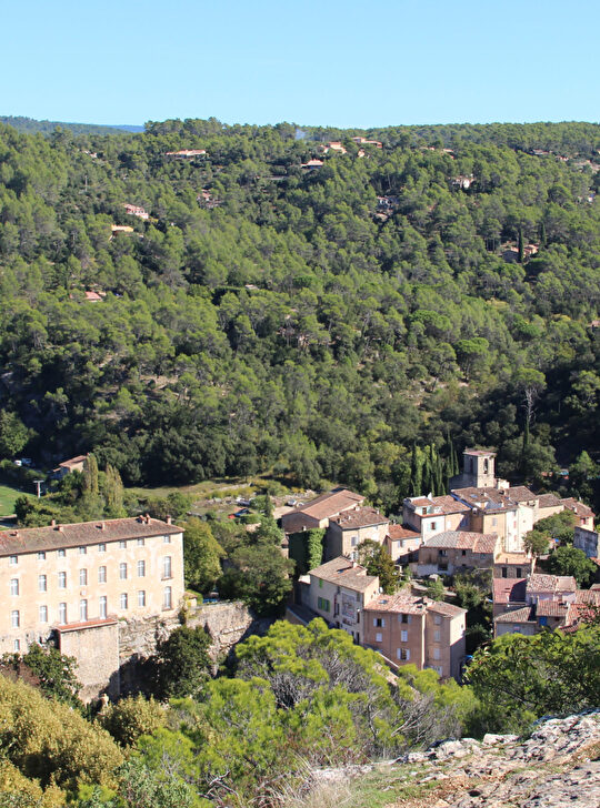 Paysage pittoresque d'un village niché au pied de collines verdoyantes.