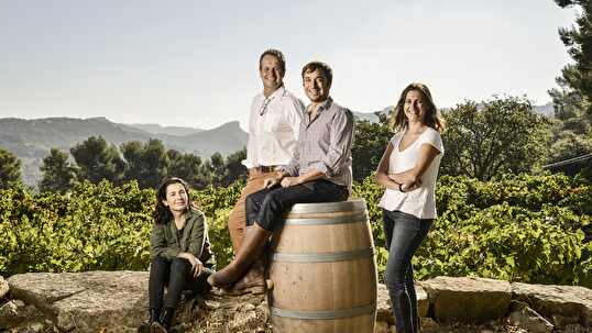 Les membres de la famille viticole, au cœur de leur vignoble, partagent leur passion pour le vin.