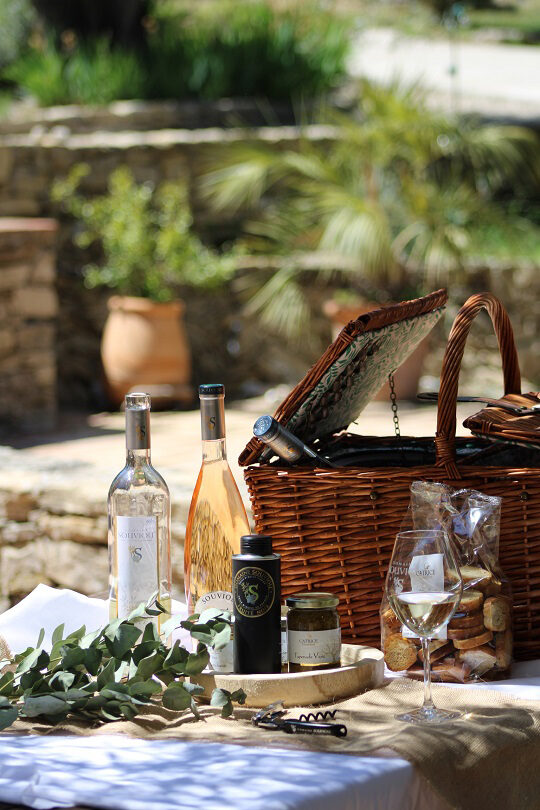 Un panier de pique-nique avec du vin et des biscuits, idéal pour une journée ensoleillée.