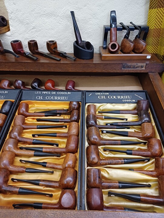 Collection de pipes en bois de Cogolin, présentées dans des boîtes dorées.